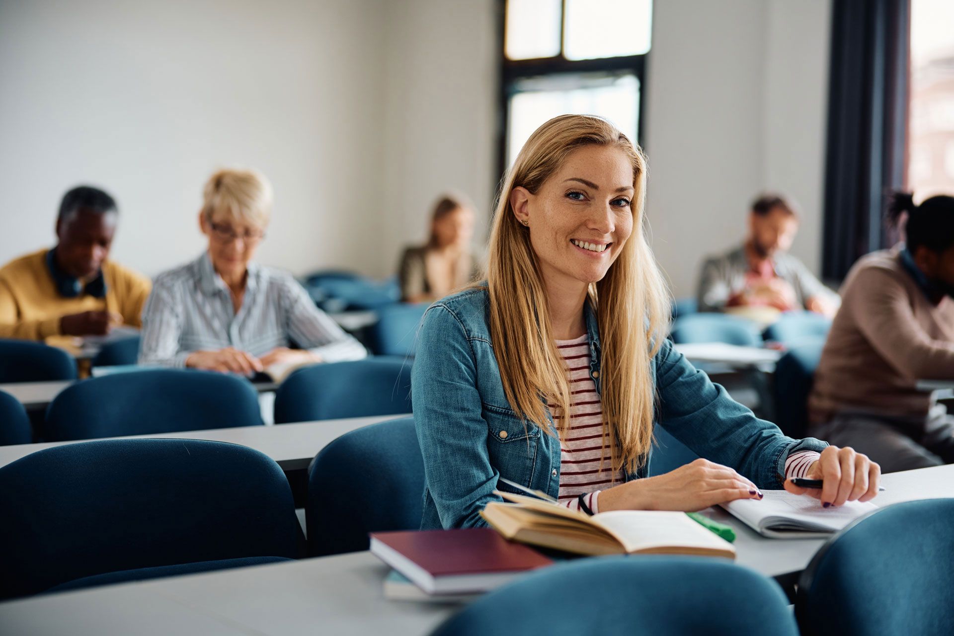 Blonde Frau die in einem Ausbildungskurs sitzt